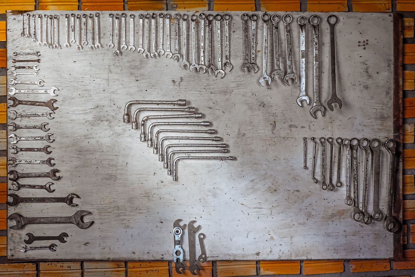 An organised board of spanners and wrenches laid out by size in a workshop